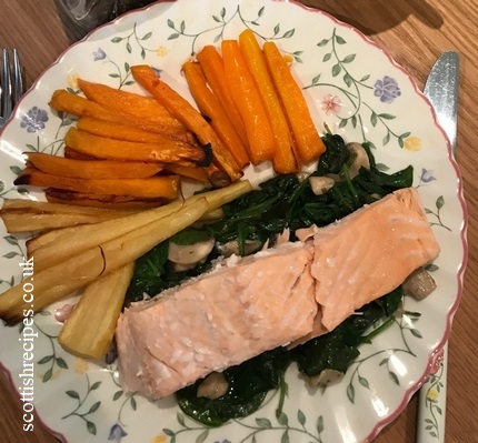 Salmon on a bed of spinach and mushrooms with roasted vegetables